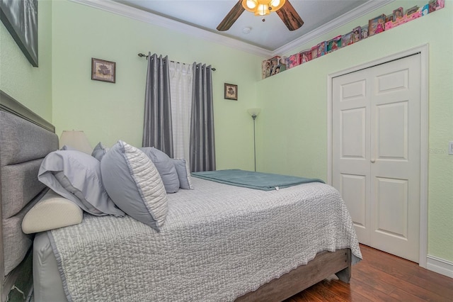 bedroom with ceiling fan, dark hardwood / wood-style flooring, crown molding, and a closet