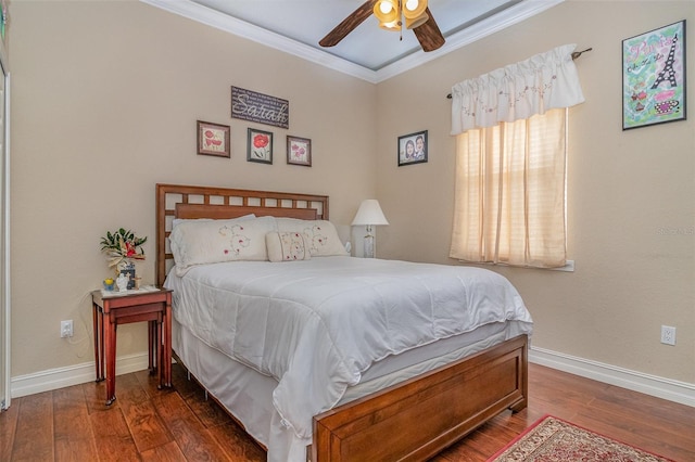 bedroom featuring dark hardwood / wood-style flooring, ceiling fan, and crown molding