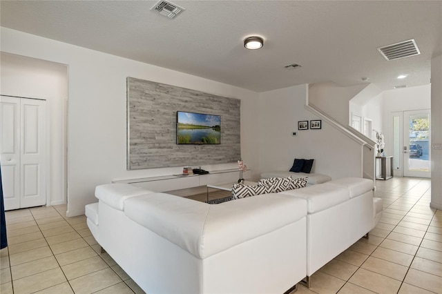 living room with a textured ceiling and light tile patterned floors