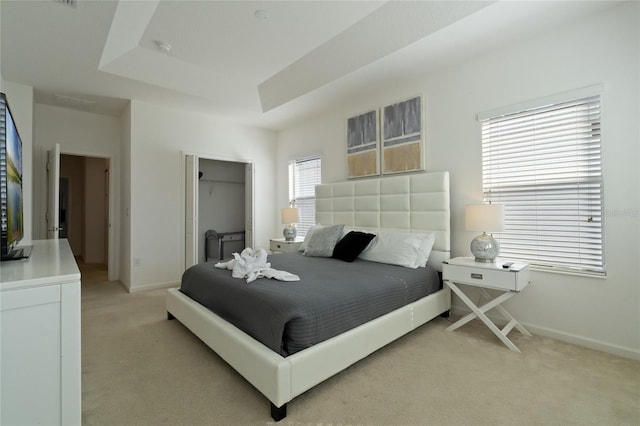 carpeted bedroom with a tray ceiling