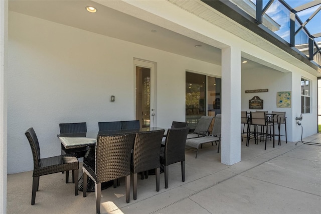 view of patio featuring glass enclosure