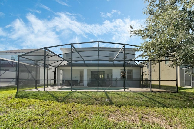 rear view of house with a patio, a lanai, and a yard