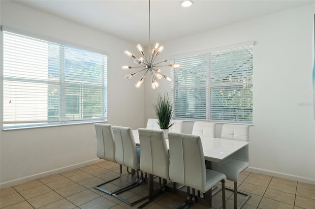 tiled dining area featuring a healthy amount of sunlight and a chandelier