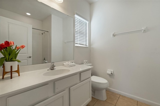 bathroom featuring vanity, toilet, tiled shower, and tile patterned flooring