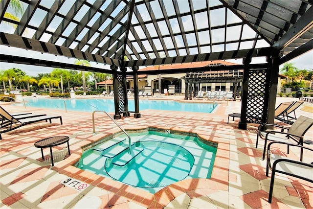 view of swimming pool featuring a community hot tub and a patio area