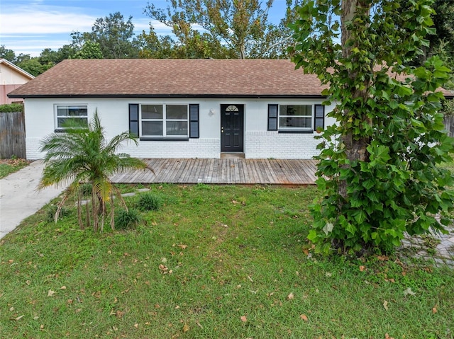 ranch-style home with a deck and a front lawn