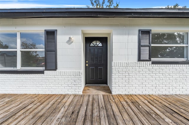 view of exterior entry with a wooden deck