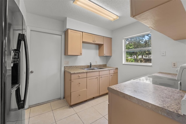 kitchen featuring light brown cabinets, stainless steel refrigerator with ice dispenser, sink, light tile patterned flooring, and a textured ceiling