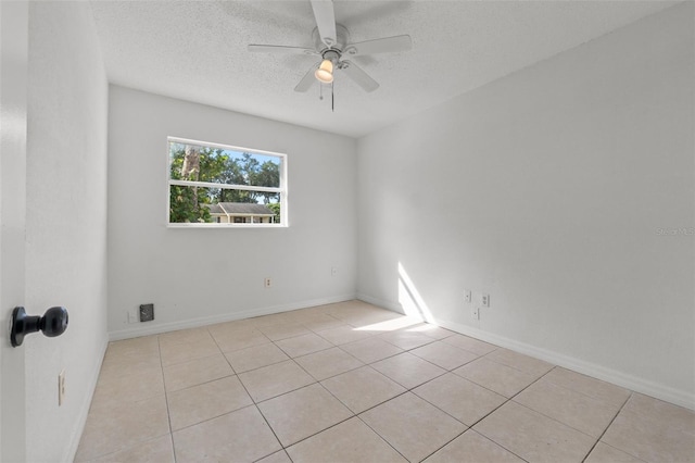 tiled empty room featuring ceiling fan and a textured ceiling