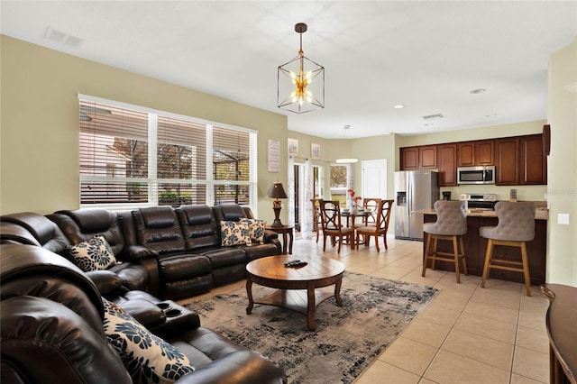 living room with a notable chandelier and light tile patterned flooring