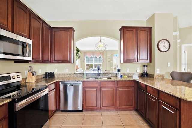 kitchen with kitchen peninsula, stainless steel appliances, sink, light stone countertops, and light tile patterned flooring