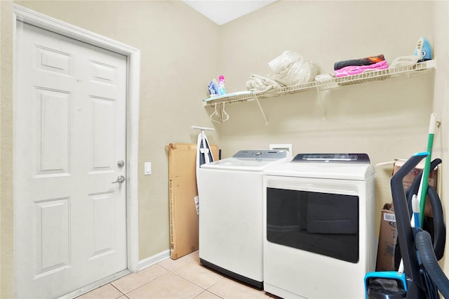 laundry room with washing machine and dryer and light tile patterned floors