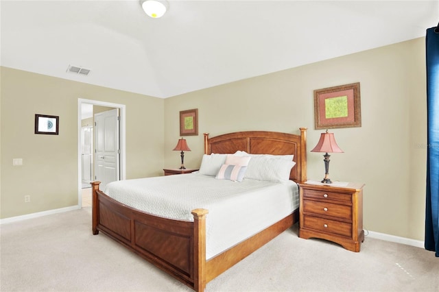 bedroom featuring ensuite bathroom and light colored carpet