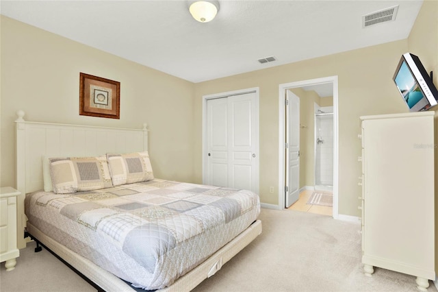 carpeted bedroom with a closet and ensuite bathroom