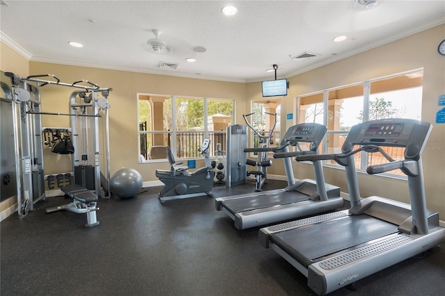 gym featuring ornamental molding, a textured ceiling, ceiling fan, and a wealth of natural light