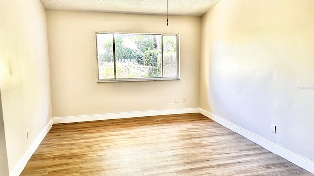 empty room featuring light hardwood / wood-style flooring and a textured ceiling