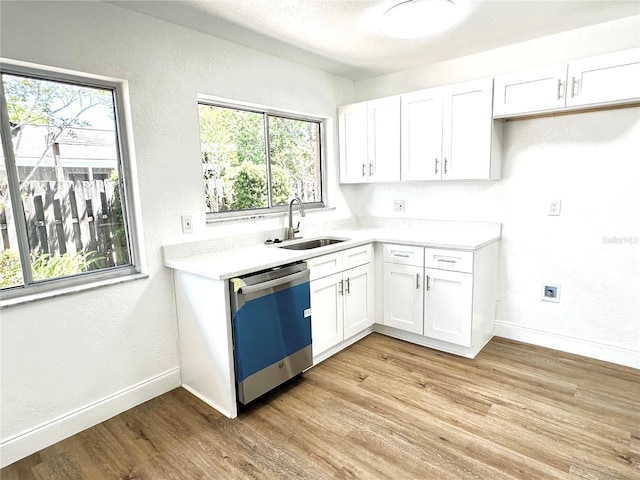 kitchen featuring sink, a healthy amount of sunlight, white cabinets, light wood-type flooring, and dishwasher