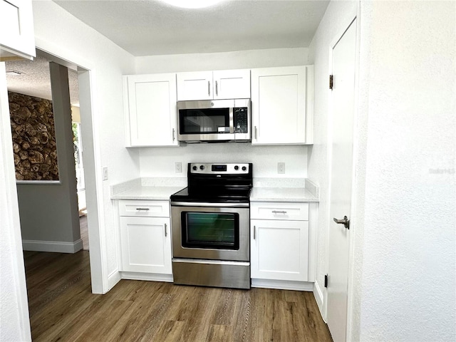 kitchen featuring white cabinetry, stainless steel appliances, and dark hardwood / wood-style flooring