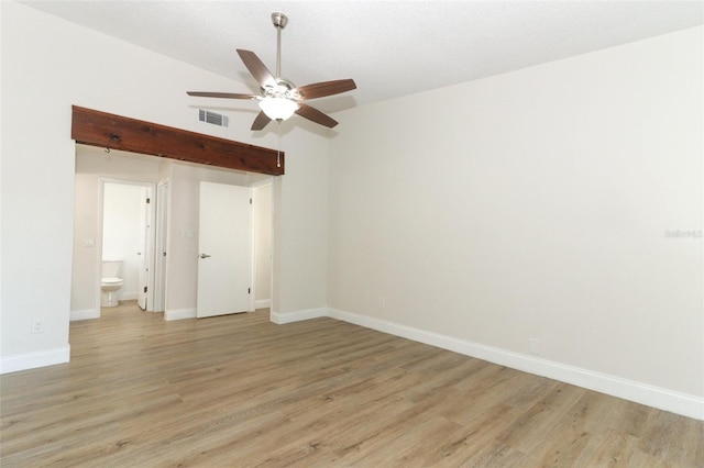 spare room with vaulted ceiling, baseboards, visible vents, light wood-style floors, and ceiling fan