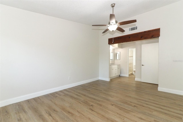 unfurnished room featuring light wood finished floors, baseboards, visible vents, and a ceiling fan