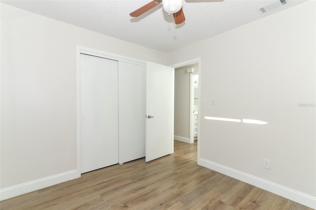 unfurnished bedroom featuring wood finished floors, baseboards, and visible vents