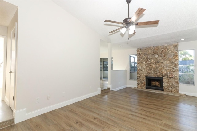 unfurnished living room with baseboards, a fireplace, and wood finished floors