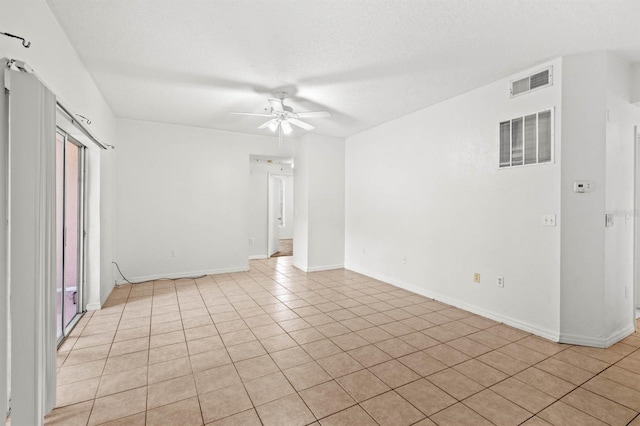 tiled spare room featuring ceiling fan and a textured ceiling