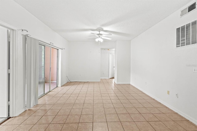 tiled empty room featuring ceiling fan and a textured ceiling