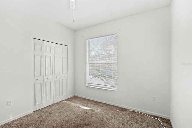 unfurnished bedroom with carpet floors, a closet, and ceiling fan