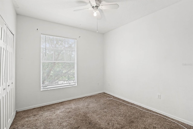 empty room featuring a wealth of natural light, carpet floors, and ceiling fan