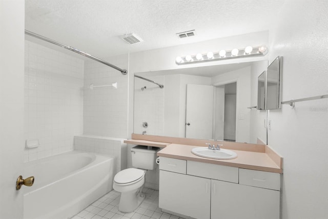 full bathroom featuring tile patterned floors, toilet, tiled shower / bath, vanity, and a textured ceiling