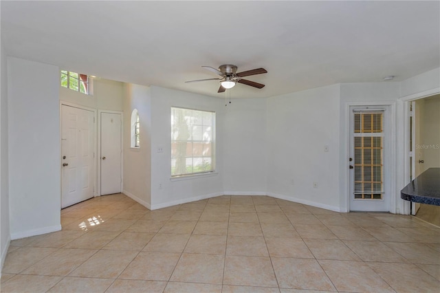 interior space with light tile patterned floors and ceiling fan