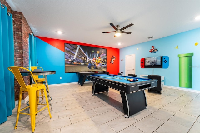 rec room featuring light tile patterned flooring, a textured ceiling, ceiling fan, brick wall, and billiards