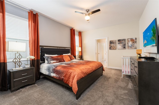 carpeted bedroom with ensuite bathroom, multiple windows, and ceiling fan