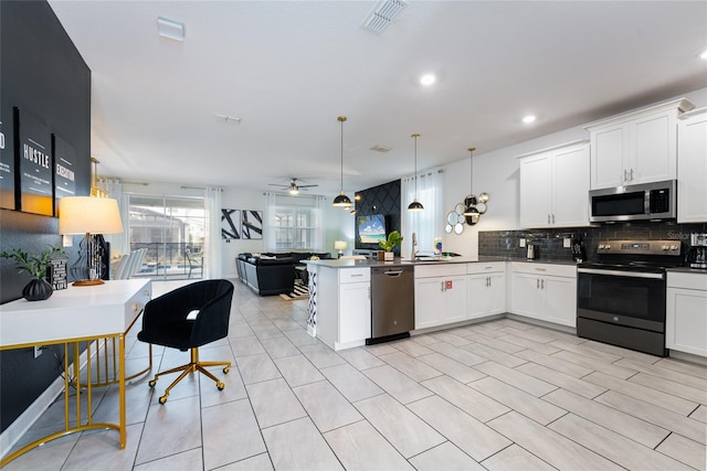 kitchen with kitchen peninsula, tasteful backsplash, ceiling fan, appliances with stainless steel finishes, and pendant lighting