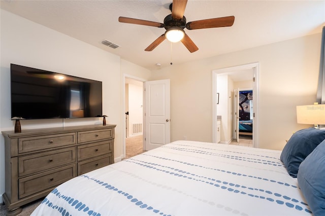 bedroom with light carpet, ensuite bath, and ceiling fan