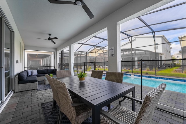 exterior space featuring outdoor lounge area, glass enclosure, and ceiling fan