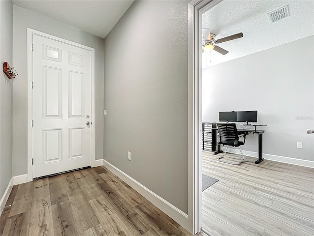 interior space featuring light hardwood / wood-style floors and a textured ceiling