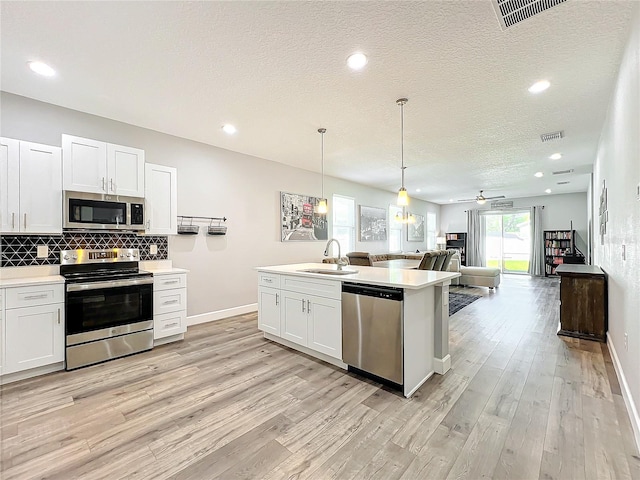 kitchen with white cabinets, stainless steel appliances, ceiling fan, and sink