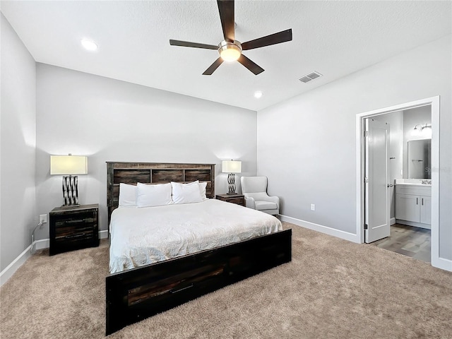 bedroom with carpet flooring, ceiling fan, ensuite bathroom, and a textured ceiling