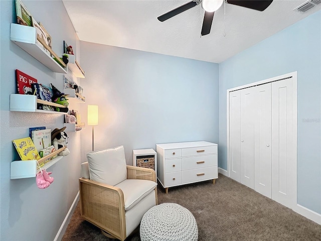 living area with ceiling fan and dark carpet