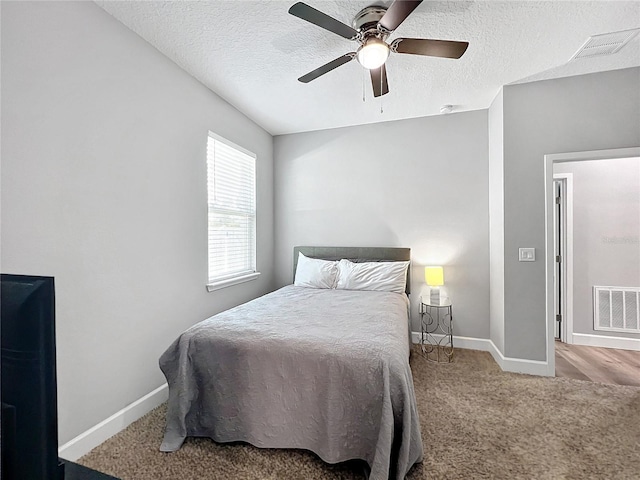 carpeted bedroom with a textured ceiling and ceiling fan