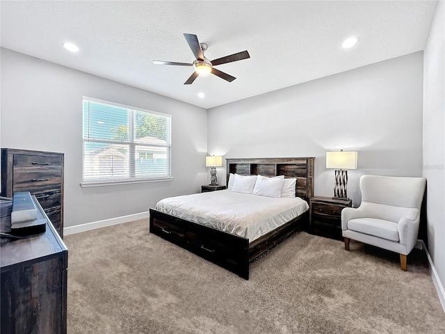 carpeted bedroom with ceiling fan and a textured ceiling