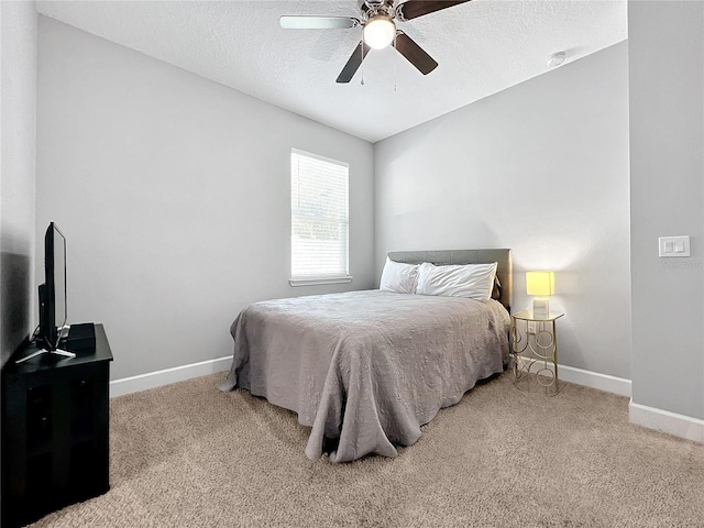 bedroom featuring a textured ceiling, ceiling fan, and light carpet