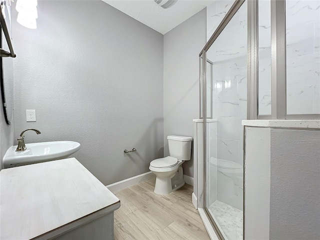 bathroom with hardwood / wood-style floors, vanity, toilet, and an enclosed shower