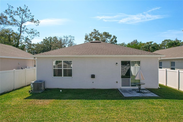 back of property featuring central AC unit and a yard