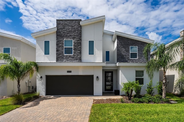 contemporary house featuring a front lawn and a garage