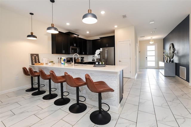 8896 Cabot Cliffs Dr, Davenport, FL 33896 - kitchen with stainless steel appliances, light marble finish floors, a peninsula, light countertops, and recessed lighting