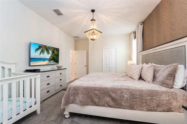 carpeted bedroom with a closet and an inviting chandelier