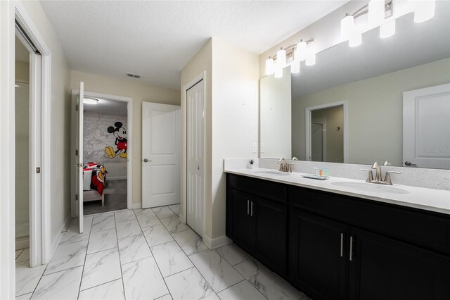 8896 Cabot Cliffs Dr, Davenport, FL 33896 - bathroom featuring double vanity, marble finish floors, and baseboards